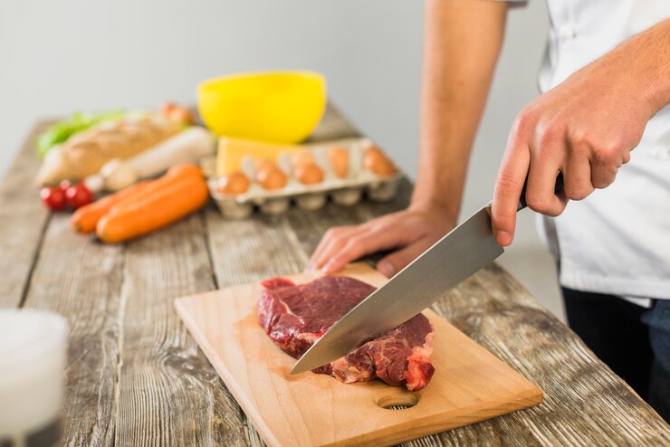Membersihkan pisau setelah memotong daging