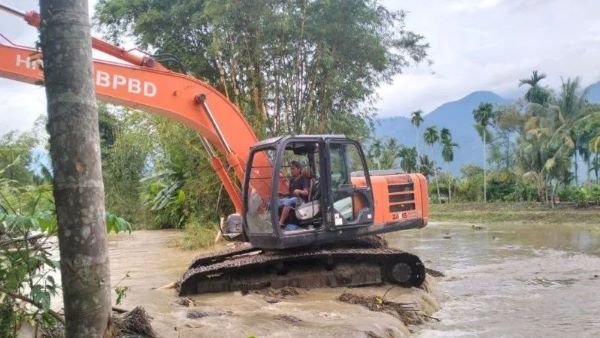 Satu alat berat berupa eskavator dikerahkan untuk memperbaiki tanggul yang jebol di Aceh Tenggara akibat diterjang banjir.(Foto: BNPB)