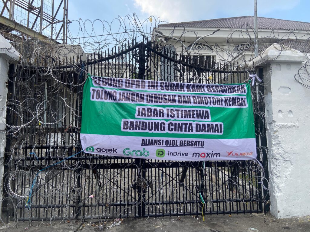 Kondisi DPRD Jabar: Gerbang Depan Kembali Bersih, Aliansi Ojol Bersatu Pasang Spanduk Pesan Damai
